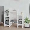 A white bookshelf with books and decorative items on it, placed on a wooden floor next to a gray armchair. Anteprima dell’immagine prodotto
