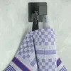 A blue checkered tea towel hanging on a hook. Produktbild-Vorschau