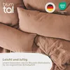 Close-up of folded bedding with text overlays and logos. Voir les images du produit