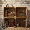 Four wooden crates stacked in a 2x2 grid, filled with books and decorative items, set against a brick wall. Náhled obrázku produktu