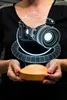 A person holds a 3D LED lamp shaped like a camera. Produktbild-Vorschau