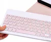 A close-up shot of a white Bluetooth keyboard with pink keys, held by a person's hand. Náhľad obrázku produktu