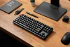 A desk setup with a mechanical keyboard, notebook, pen, and mouse. Produktbild-Vorschau