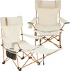 Two beige camping chairs with wooden frames are shown against a white background. One chair is in the foreground and slightly to the left, with its footrest extended. The other chair is in the background and slightly to the right, appearing larger and more Produktbild-Vorschau