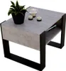 A modern rectangular coffee table with a concrete-look top and black metal legs, featuring a potted plant and candles.