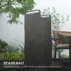 A black metal firewood rack is shown outdoors in the rain, with plants and a chair in the background. Produktbild-Vorschau