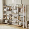 Two white and wood-colored bookshelves filled with books and decorative items, placed in a room with a window and a rug. Produktbild-Vorschau