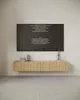 A modern living room with a wall-mounted TV board and a TV displaying credits. Produktbild-Vorschau
