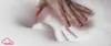 A hand pressing into a white, soft material, likely a mattress or pillow. Produktbild-Vorschau