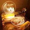 Two LED Ramadan-themed decorative lights are displayed on a wooden surface, with a golden lantern in the foreground. Produktbild-Vorschau