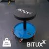 A blue mechanic's stool with a black padded seat sits on a grey floor. Produktbild-Vorschau