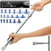 A hand holding a dent puller tool with various suction cups laid out. Produktbild-Vorschau