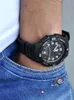 A close-up shot of a person's wrist wearing a black Casio watch, with the watch partially tucked into the pocket of blue jeans. Produktbild-Vorschau