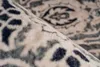 A close-up view of a rolled-up rug with a detailed pattern. Produktbild-Vorschau