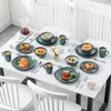 A table set for a meal with plates, bowls, cups, and food. Náhled obrázku produktu