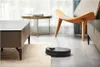 A robot vacuum cleaner is cleaning a modern living room floor next to a coffee table and a chair. Podgląd zdjęcia produktu