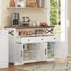 A white buffet-anrichte with a wood-tone top, featuring three drawers and two cabinet doors, is shown in a well-lit room with a window in the background. Podgląd zdjęcia produktu