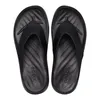A top-down view of a pair of black Crocs flip-flops on a white background. Voir les images du produit