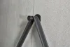 A close-up shot of a black leather strap with white stitching hanging from a dark metal hook mounted on a gray tiled wall. Anteprima dell’immagine prodotto