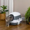 A cat is exiting a covered litter box next to a potted plant. Náhled obrázku produktu