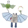 Two plush bat toys hanging against a white background. One is green with striped wings, and the other is gray with blue polka dot wings and striped legs. A clear rattle ring is attached to the gray bat. Produktbild-Vorschau