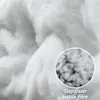 A close-up view of white textile fibers, with a magnified circular inset showing more detail of the fibers. Produktbild-Vorschau