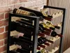 A wine rack filled with wine bottles, placed against a brick wall. Produktbild-Vorschau