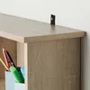 A close-up view of a wooden shelf with office supplies. Náhled obrázku produktu