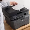 A person is placing a document into a Brother printer. Produktbild-Vorschau