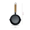 A black cast iron mini frying pan with a wooden handle is shown against a white background. Dimensions are indicated by text overlays. Náhľad obrázku produktu