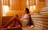 A woman relaxing in a wooden sauna, with a small device on the bench. Voir les images du produit