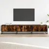 A long, low media console with a wood-grain finish and black metal frame, placed against a white wall with a large flat-screen TV mounted above it. A light-colored rug is in the foreground. Náhľad obrázku produktu