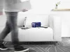 A person walks past a couch with a laptop and a blue scanner on it. Náhľad obrázku produktu
