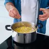 A person is adding salt to a pot of boiling pasta. Podgląd zdjęcia produktu