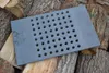 A cast iron grate with holes is placed on a pile of firewood. Voir les images du produit