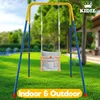 A baby swing set is displayed outdoors on a grassy lawn with a house in the background. Produktbild-Vorschau