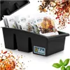 A black spice organizer with several spice packets inside, surrounded by scattered spices and herbs. Náhľad obrázku produktu