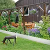 A garden scene with a wooden pergola, outdoor furniture, and flowers, featuring a metal garden edging product. Náhľad obrázku produktu