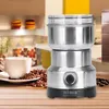 A coffee grinder and coffee beans are displayed on a wooden table in a kitchen setting. Podgląd zdjęcia produktu