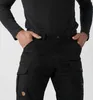 Close-up of a person wearing black cargo pants and a black long-sleeved shirt. Produktbild-Vorschau