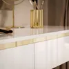 A close-up view of a white, high-gloss console table with a gold accent strip. Náhled obrázku produktu
