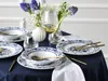A table setting with floral arrangements and white and blue patterned dinnerware. Náhľad obrázku produktu