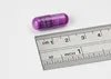 A purple capsule next to a ruler on a white background. Podgląd zdjęcia produktu