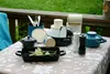A collection of kitchenware and storage containers arranged on a table outdoors. Anteprima dell’immagine prodotto