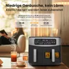 A woman is sitting on a couch in the background, reading a book, while an air fryer is in the foreground with drinks next to it. Produktbild-Vorschau