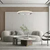 A modern living room with a sofa, coffee table, and a hanging lamp. Produktbild-Vorschau