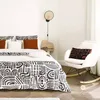 A bedroom scene with a bed, a rocking chair, and a bedside table. Produktbild-Vorschau
