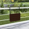 A dark brown slatted table is attached to a white railing on a balcony, with a background of green grass and trees. Podgląd zdjęcia produktu