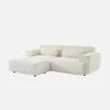 A cream-colored sectional sofa with an ottoman, shown against a white background. Produktbild-Vorschau