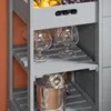 A close-up view of a gray kitchen cart with various items on its shelves, including glassware and an ice bucket. Produktbild-Vorschau